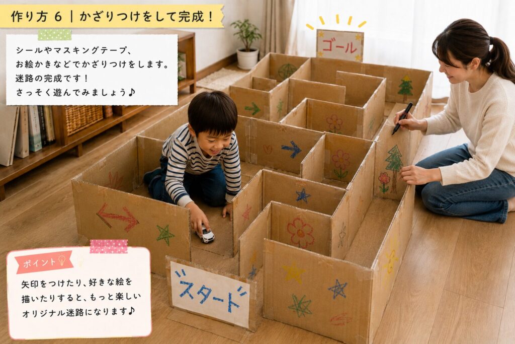 親子でダンボール迷路にクレヨンで矢印や星、花などをラフに描き、飾りつけをして完成させている工程画像